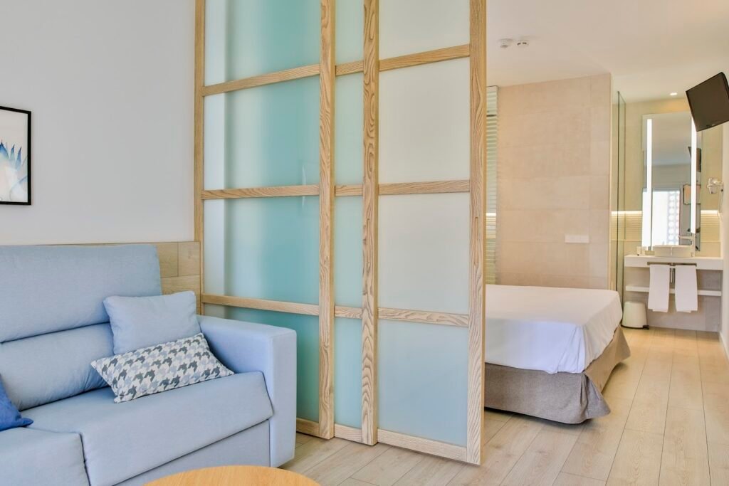 Apartamento con dormitorio y baño separados por un panel de madera